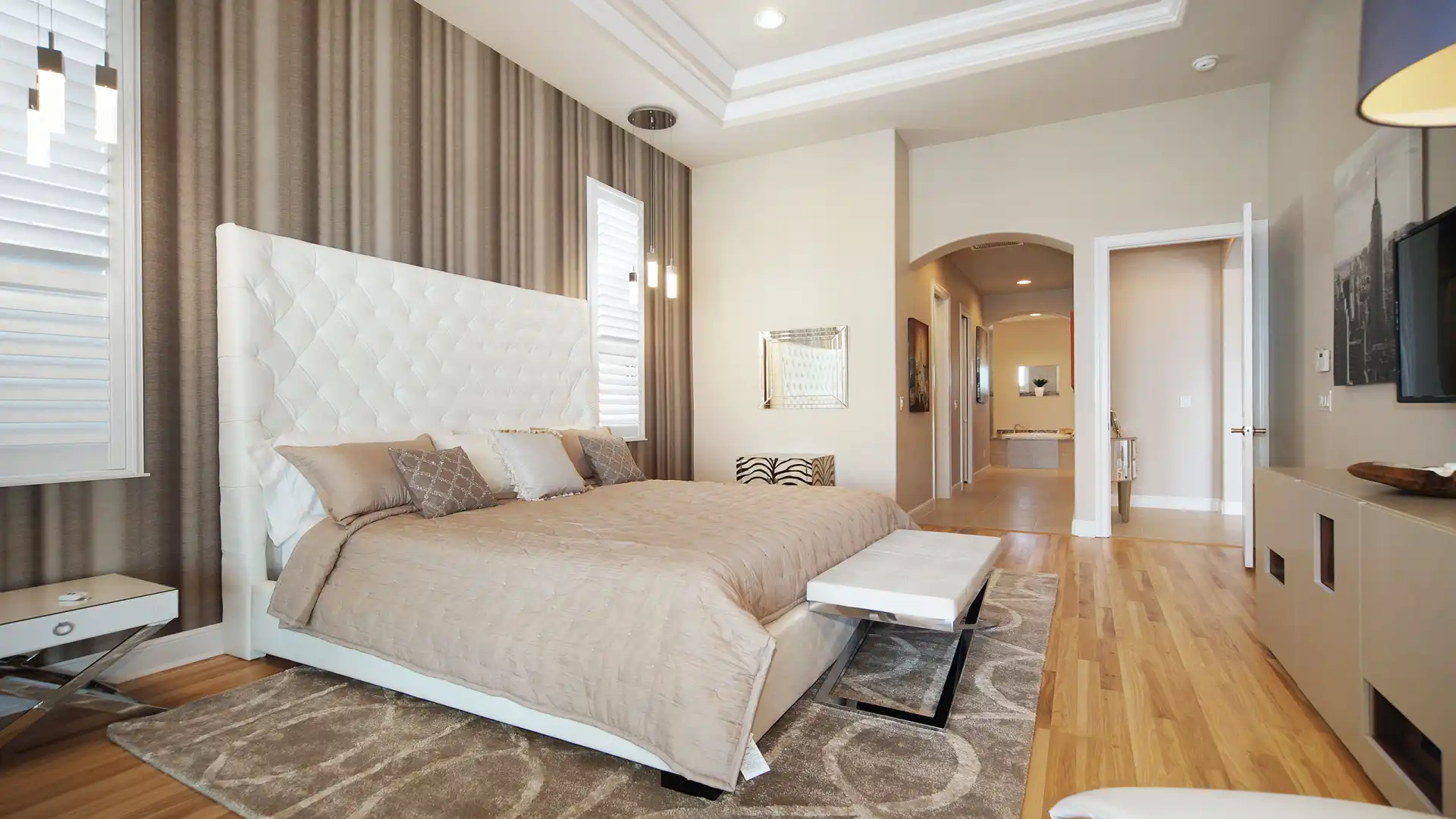 Cozy master bedroom with a large bed, modern accents, and a view of the adjoining bathroom.