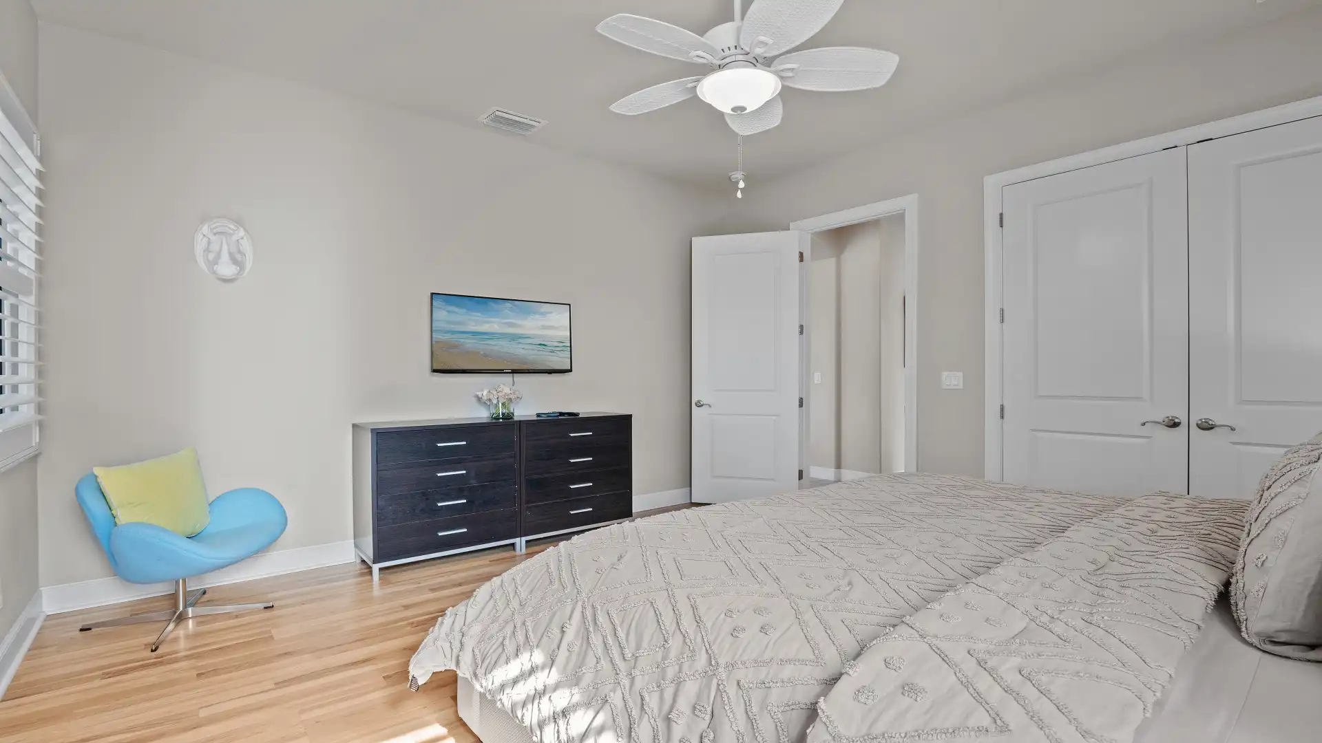 Bedroom with stylish decor, ceiling fan, and modern furnishings.