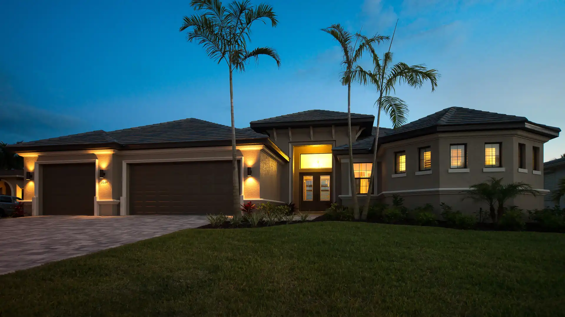 Exterior view of a luxurious vacation home at dusk with atmospheric lighting.