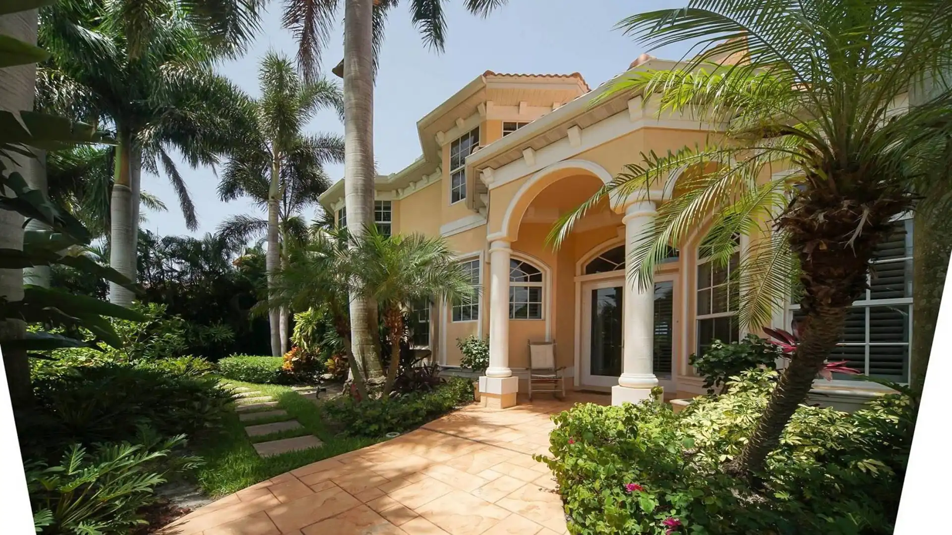 Large palm trees and flowering shrubs in the front garden of Villa Mone Reve