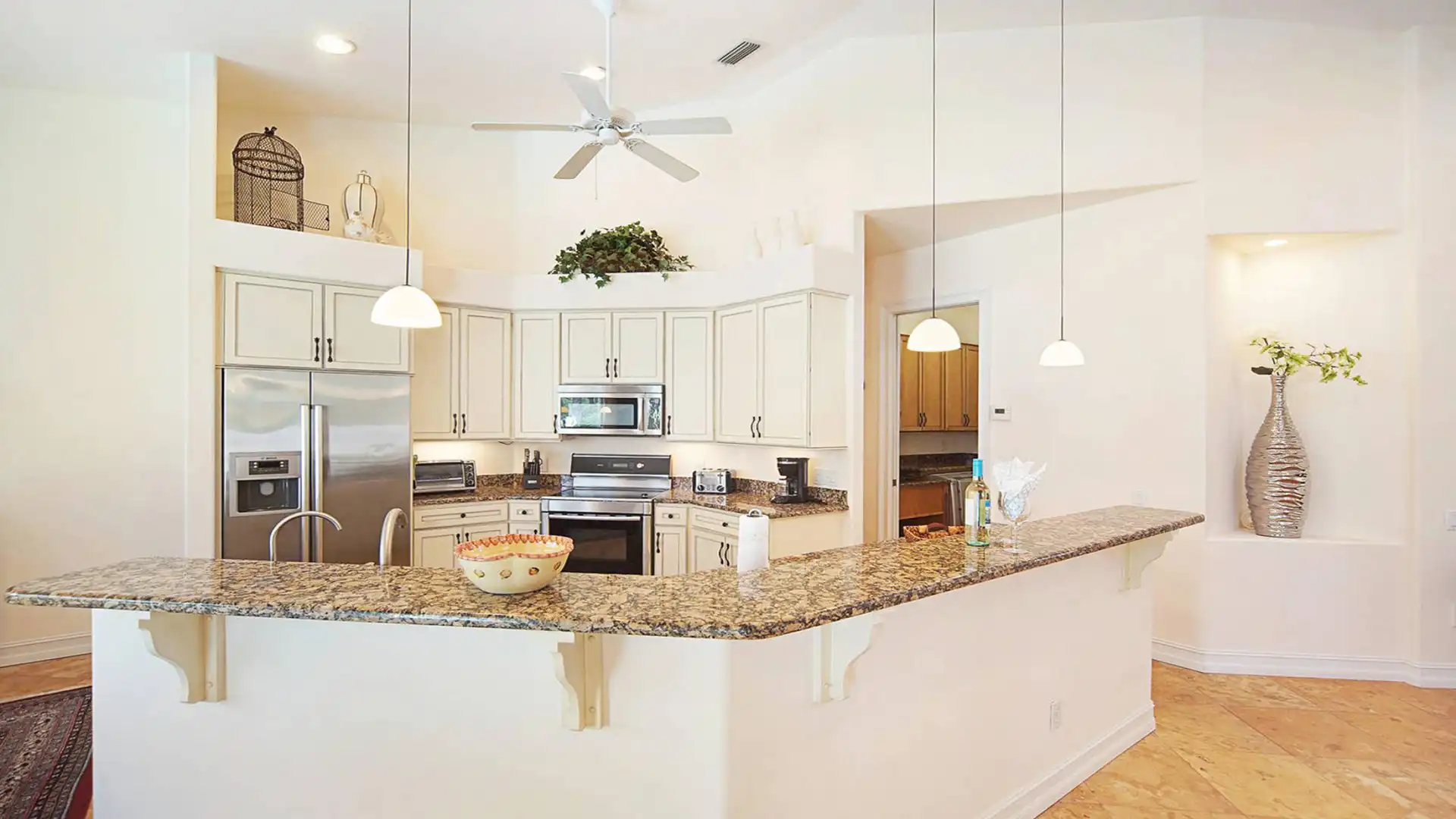 The kitchen is fully equipped and, like the dining room, overlooks the pool area