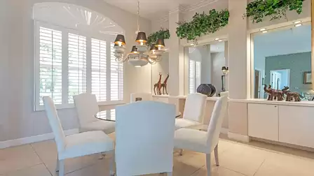 Stylish dining area with glass table and white chairs