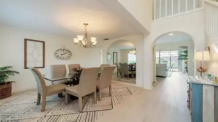 Chic and tasteful separate dining area with glass dining table and 6 gray chairs