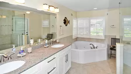 The large bathroom adjoining the master bedroom is presented in elegant white